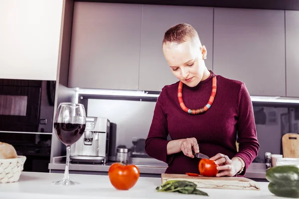Концентрированная молодая женщина готовит овощи для салата — стоковое фото