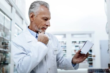 Düşünme süreci. Olgun adamla sakallı: yüz kırışıklık onun eczane dururken düşünceli arıyorum