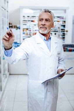 Beyaz önlük meşgul seyir yakışıklı sakallı eczacı