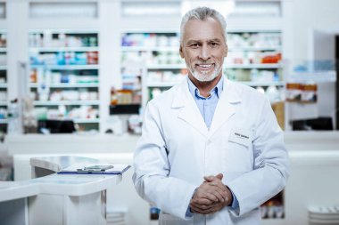 Kara gözlü olgun güneş yanığı adam Beyaz paltolu günün iyi geçiyor