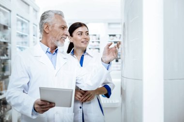 Bir eczanede ilaçlar yeni meslektaşı sunan beyaz önlük Direktörü