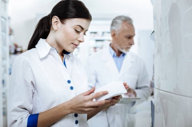 Vitaminler kutusuyla tutan güzel gülen uzun saçlı kadın