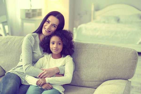 Mujer caucásica y su hija adoptiva marrón posando para la foto . —  Fotos de Stock