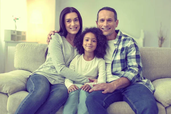 Família unida de três relaxantes no sofá juntos . — Fotografia de Stock