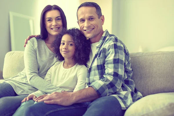 Sonrientes padres felices abrazando a su hermosa hija . —  Fotos de Stock