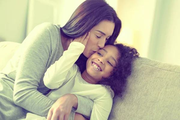 Hermosa mujer cariñosa besando a su hija en la mejilla . — Foto de Stock