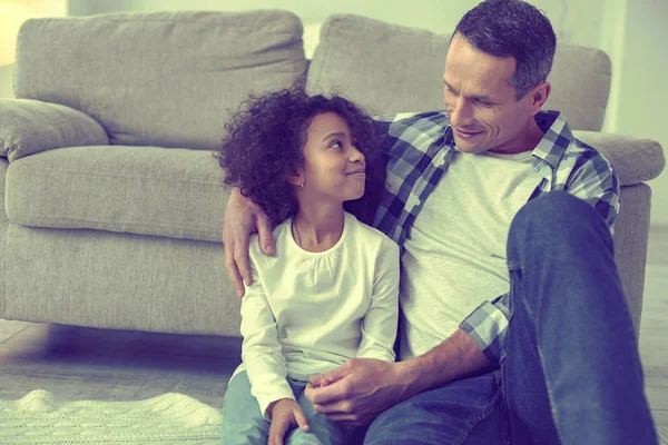 Happy mulatto girl showing her love to her adoptive dad. — Stock Photo, Image