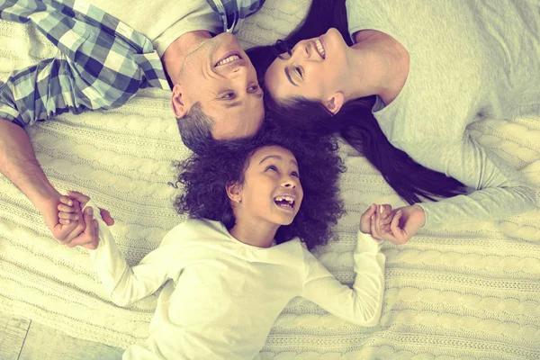 United beautiful family lying down on a comfortable bed. — Stock Photo, Image