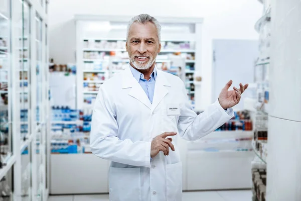 Взрослый мужчина с морщинами на лице, стоящий в аптеке. — стоковое фото