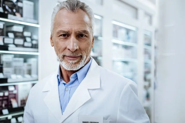 Grauhaarige Babyboomer im weißen Mantel lächeln positiv — Stockfoto