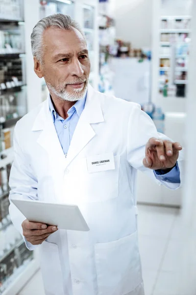 Director of a drugstore in a white coat looking attentive