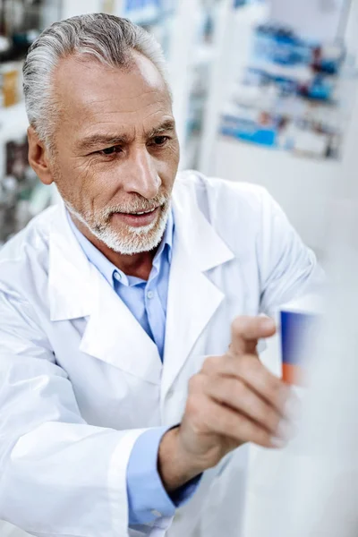 Бородатий сонячний фармацевт у білому пальто виглядає серйозно — стокове фото