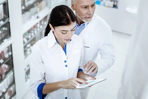 Due farmacisti in camici bianchi che lavorano insieme in una farmacia — Foto Stock