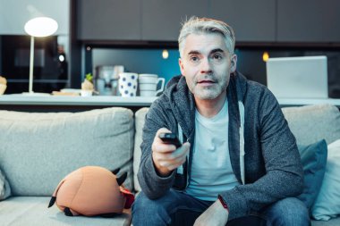 Tv izlerken spor giyim çekici adam gri saçlı sakallı