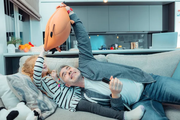 Schattig langhaar meisje in een jurk en haar vader samenspelen — Stockfoto