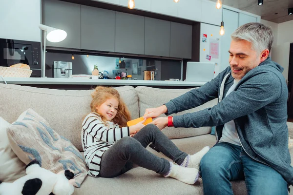 Bella ragazza dai capelli lunghi in un vestito e il suo padre dai capelli grigi sentirsi sciocco — Foto Stock