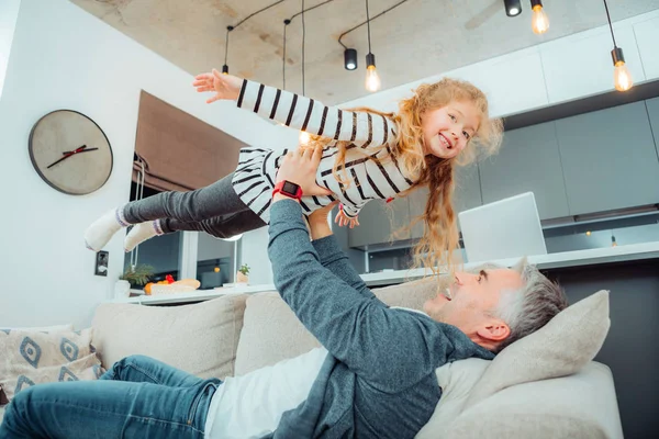 Söt liten dotter med långt hår ser roade — Stockfoto