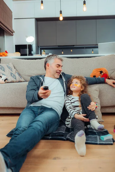 Pretty small long-haired girl with eye patches and her father looking at each other — Stock Photo, Image