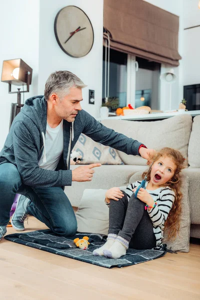 Hermoso padre alto de pelo gris con un reloj rojo que habla estrictamente con su hija — Foto de Stock