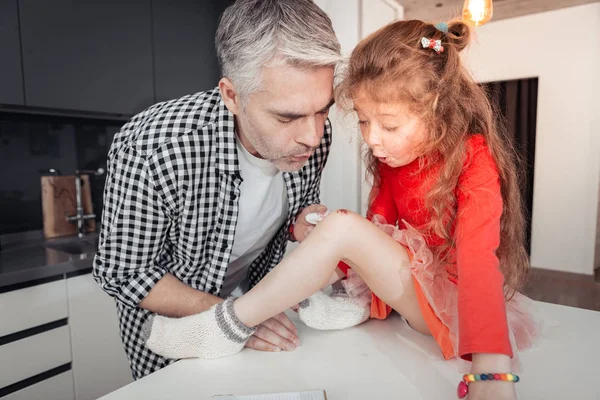 Bastante pequeña chica de pelo largo y su padre buscando ocupado —  Fotos de Stock