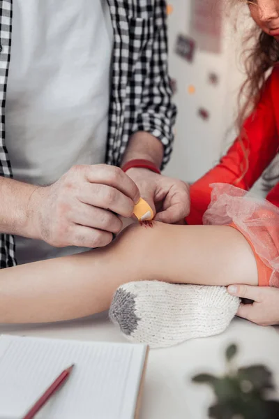 Großer grauhaariger Vater mit roter Uhr an der Hand, der seine Tochter heilt — Stockfoto