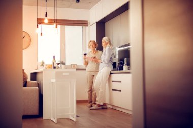 Tablet ekrana bakarak neşeli yaşlı kadın