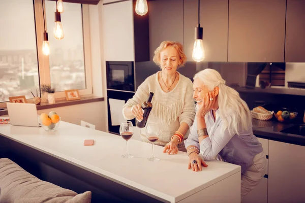 Gelukkig bejaarde vrouw met een fles wijn — Stockfoto