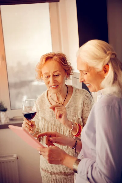 Веселые пожилые женщины с использованием современных технологических устройств — стоковое фото