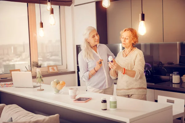 Aangename senior vrouwen nieuwe geneeskunde met elkaar bespreken — Stockfoto