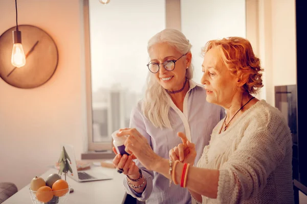 Positief ouder vrouwen houden van een fles met vitamines — Stockfoto