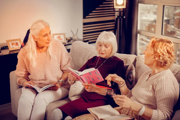 Приятные пожилые женщины, сидящие вместе на диване — стоковое фото