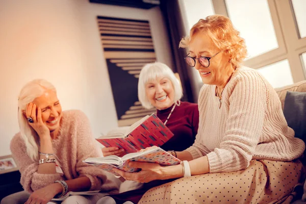 Agradable mujer agradable sosteniendo su libro favorito — Foto de Stock