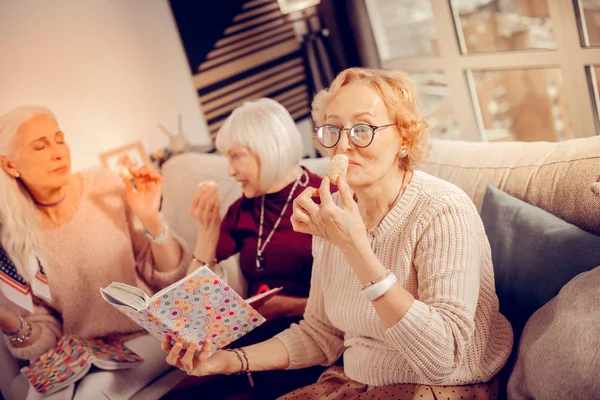 Mooie positieve leeftijd vrouw ruiken een cookie — Stockfoto