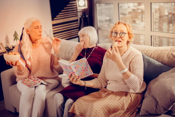 Mujer mayor positiva sosteniendo una galleta casera — Foto de Stock