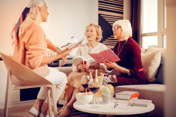Joyful grey haired woman sitting in front of her friends — Stock Photo, Image
