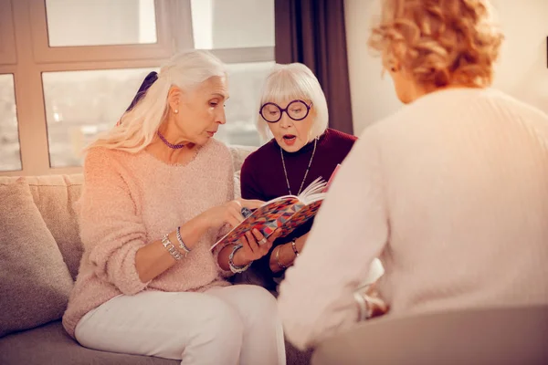 Agradable mujer emocionada mirando el libro — Foto de Stock