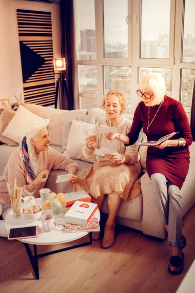 Aangename oudere vrouwen kijken naar oude foto 's — Stockfoto