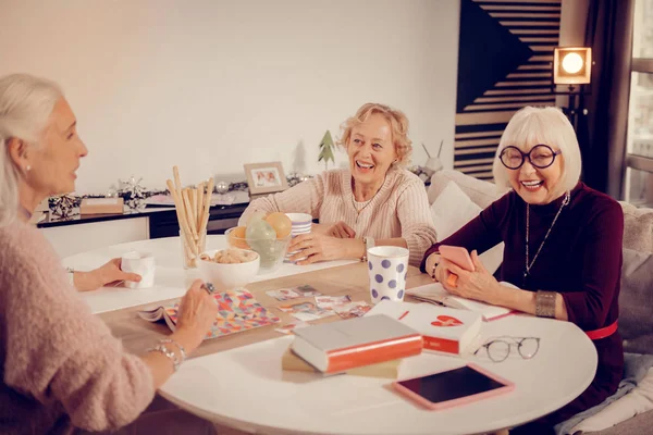 Donne anziane positive sedute intorno al tavolo — Foto Stock