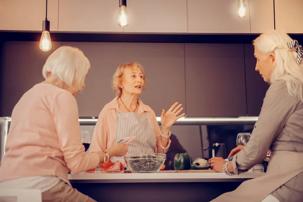Agradable anciana hablando con sus amigos — Foto de Stock