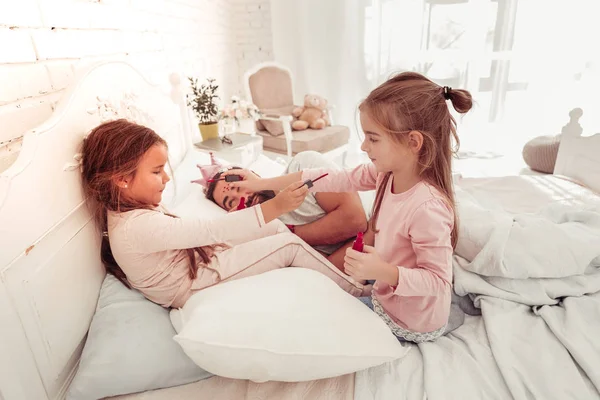 Pretty cheerful girls playing with nail polish — Stock Photo, Image