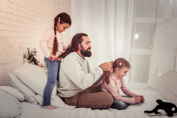 Piacevole bell'uomo che fa una treccia per sua figlia — Foto Stock