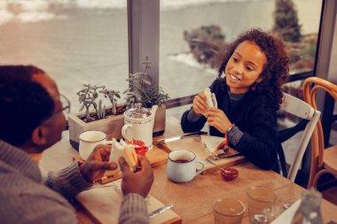 Sevimli kara gözlü kızı öğle yemeği yemeyi parlak küpeler