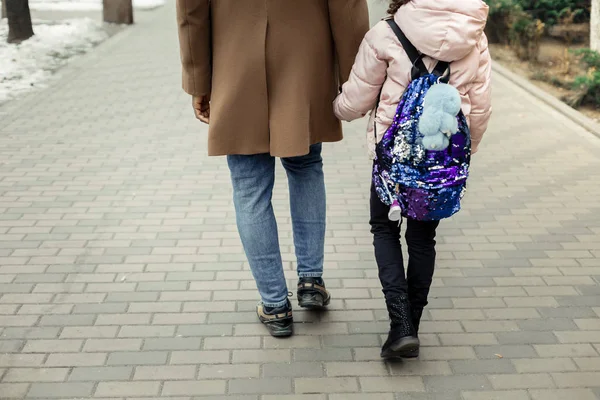 Hija vistiendo chaqueta de invierno rosa cogida de la mano de su padre — Foto de Stock