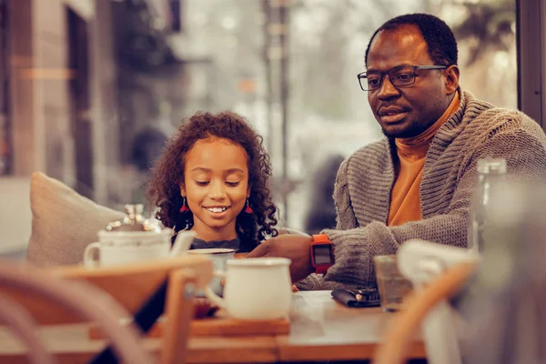 Beautiful curly daughter feeling excited having lunch with father — Stock Photo, Image