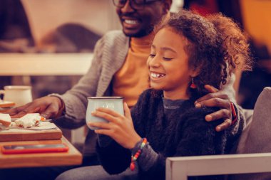 Renkli aksesuarlar çay tutan giyen sevimli neşeli kızı