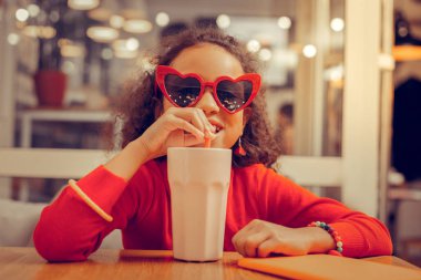 Kıvırcık çekici kız onun milkshake zevk bilezik giyiyor