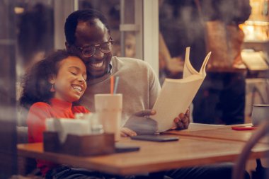 Sevimli kıvırcık kızı babasının omzuna yaslanmış