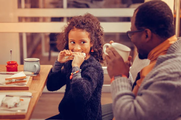 Homme heureux regardant sa fille mignonne manger sandwich — Photo