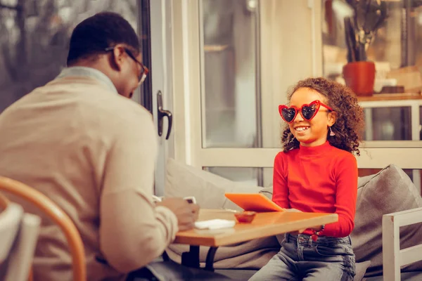 Cute girl looking funny wearing red heart-shaped glasses — Stock Photo, Image