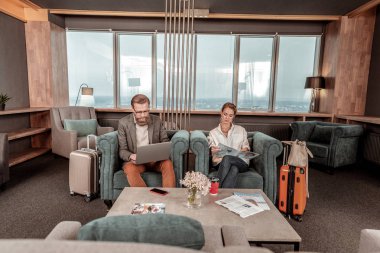 Sıkılmış kız toplantı için beklerken dergi okuma